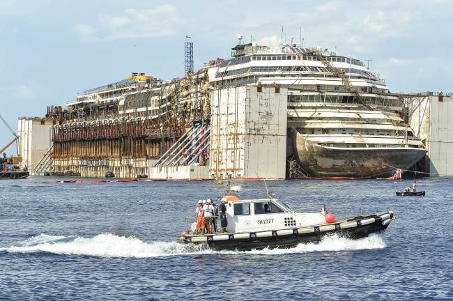 <YONHAP PHOTO-0022> This photo shows the wreck of the Costa Concordia cruise ship in front of the harbour of Isola del Giglio, after it was refloated using air tanks attached to its sides, on July 22, 2014 off Giglio Island. The Costa Concordia is due to be towed away on July 23, 2014 from Giglio Island, where it crashed on the night of January 13, 2012 in a disaster that killed 32 people. The ship's final journey for scrapping in the port of Genoa in northwest Italy is set to take four days. AFP PHOTO / ANDREAS SOLARO../2014-07-23 00:10:47/ <저작권자 ⓒ 1980-2014 ㈜연합뉴스. 무단 전재 재배포 금지.>
The wreck of the Costa Concordia cruise ship is seen in front of the harbor of Isola del Giglio, after it was refloated using air tanks attached to its sides off Giglio Island, Italy, Tuesday.   AFP-Yonhap