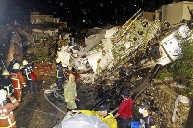 Rescue workers sift through the wreckage of TransAsia Airways Flight GE222, which crashed while attempting to land in stormy weather on the Taiwanese island of Penghu late Wednesday.   AP-Yonhap