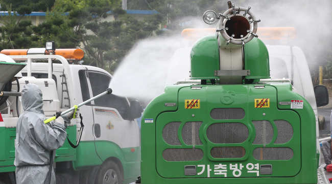 An official sprays disinfectant at a checkpoint in Uiseong, North Gyeongsang Province, where the first case of foot-and-mouth disease since the April 2011 outbreak was confirmed on Thursday. About 600 pigs were slaughtered at the Uiseong farm, and the authorities launched a multi-organization response to contain the outbreak.   Yonhap