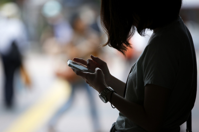 A woman uses her smartphone in Tokyo.   Bloomberg