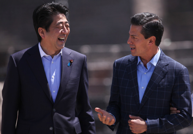 Japan’s Prime Minister Shinzo Abe (left) and Mexico’s President Enrique Pena Nieto talk before an official photo is taken in front of the Pyramid of the Moon, during a tour of the Teotihuacan archeological site on the outskirts of Mexico City, Saturday.    AP-Yonhap