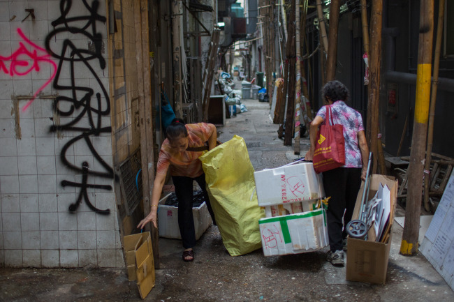 Elderly women collect cardboard and styrofoam boxes to sell in the Sheung Wan area of Hong Kong. (Bloomberg)