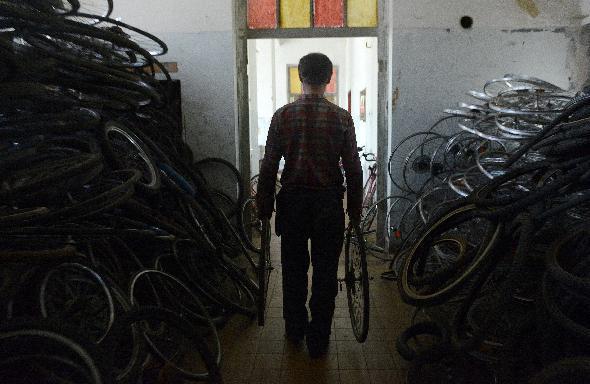 A manager of the charity Bikes for Africa, which collects old bikes for people in Gambia, carries wheels of bikes for repair in Hermanice prison in Ostrava city, Czech Republic. (AFP)
