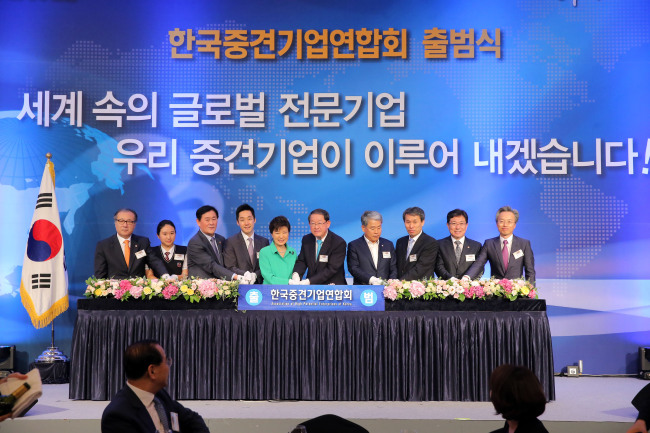 President Park Geun-hye hits a button to announce the launch of a business association representing mid-sized South Korean firms at Lotte Hotel in downtown Seoul on July 22.   Yonhap
