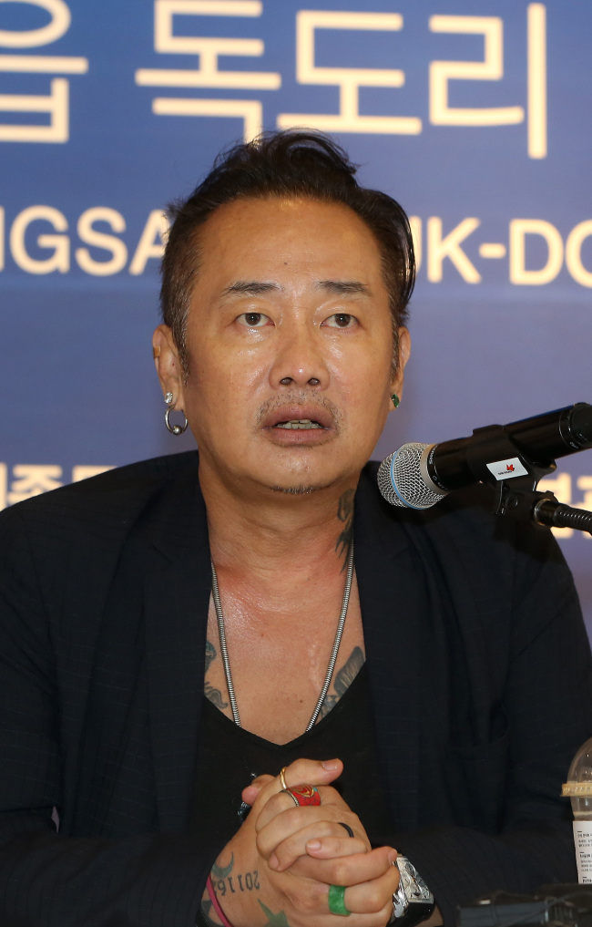 Photographer Kim Jung-man speaks at the press preview of the Dokdo exhibition at the Sejong Center for the Performing Arts on Monday. Yonhap