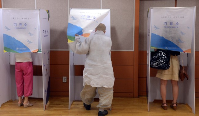 Residents cast their votes at a Dongjak-B polling station on Wednesday.   Ahn Hoon/The Korea Herald