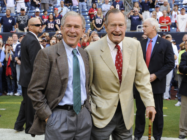 Former presidents George H. W. Bush (right) and George W. Bush before the Houston Texans football game against the San Francisco 49ers in Houston, Oct. 25, 2009   AP-Yonhap