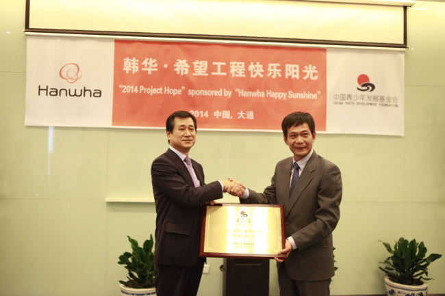 Nam Seong-woo (left), CEO of Hanwha SolarOne, and Tu Meng, secretary general of the China Youth Development Foundation, pose after signing an agreement to carry out 2014 Project Hope sponsored by Hanwha Happy Sunshine, Tuesday.   Hanwha Group