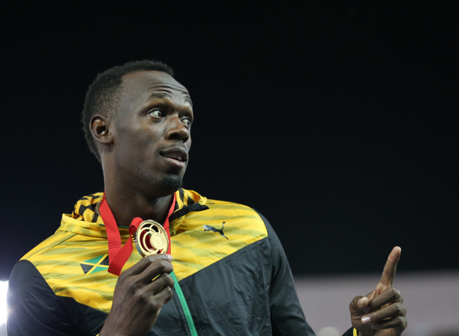 Usain Bolt poses with his gold medal Saturday.   AP-Yonhap