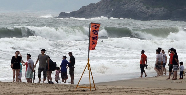 Summer vacationers are banned from swimming at Haeundae Beach, Busan, during a high tide alert on Sunday as Typhoon Nakri hit the southern coast.   Yonhap