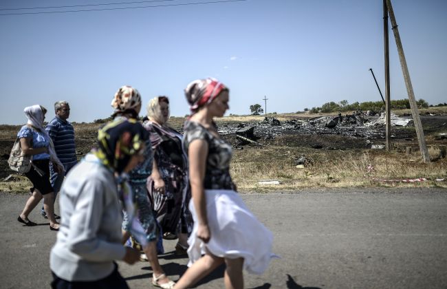 People walk at the crash site of the Malaysia Airlines flight MH17 near the village of Grabovo, east of Donetsk, Ukraine, Saturday.   AFP-Yonhap