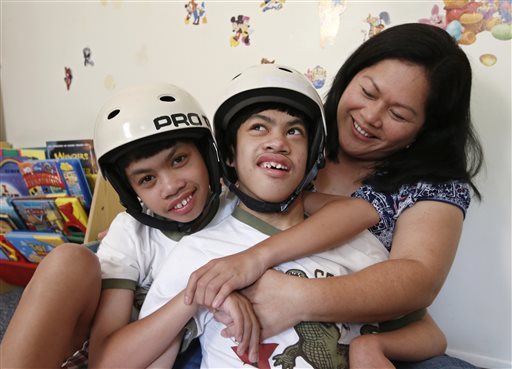 Arlene Aguirre (right) tells stories about her son Carl, as she sits with Carl’s twin brother Clarence, 12, at the family’s home in Scarsdale, New York, July 31.   AP