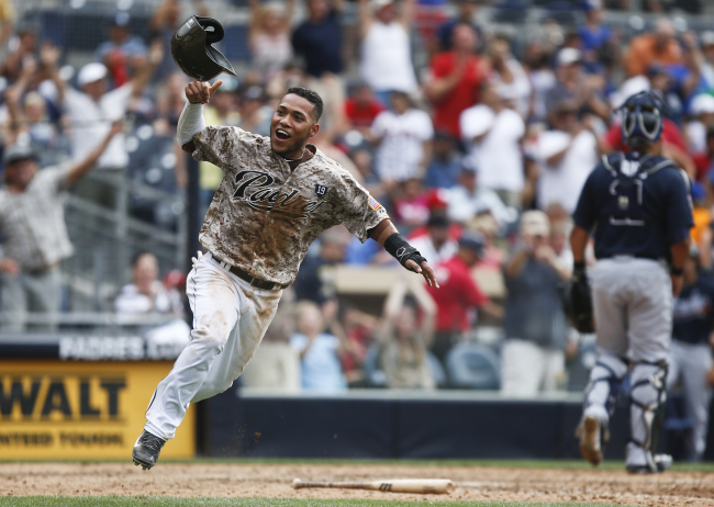 San Diego Padres’ Alexi Amarista throws his helmet in the air as he scores the game-winning run on a single by Everth Cabrera in the 10th inning against the Atlanta Braves on Sunday.   AP-Yonhap