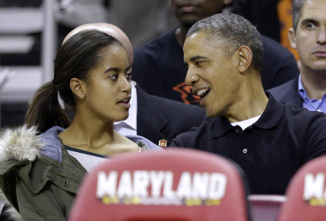 This file photo shows President Barack Obama as he chats with daughter Malia before an NCAA college basketball game between Maryland and Oregon State in College Park, Maryland.    AP