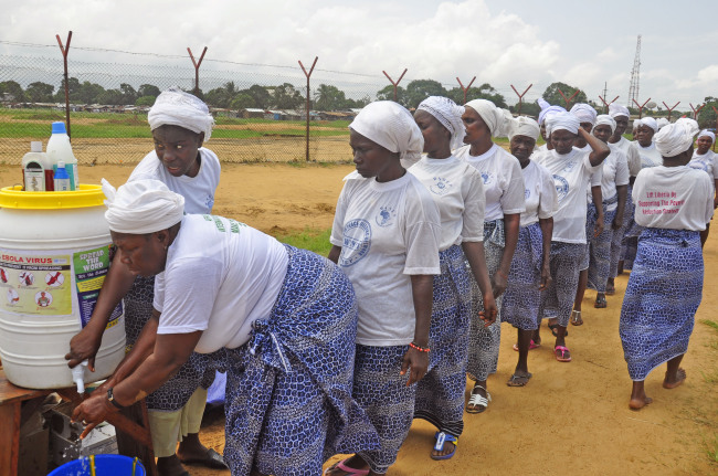 Woman from different religious groups wash their hands after praying to prevent the spread of the Ebola virus, in Monrovia, Liberia, Sunday.   AP-Yonhap