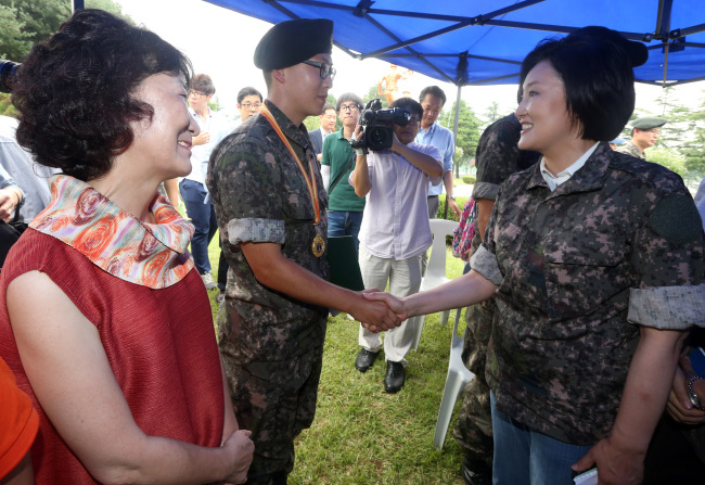 Rep. Park Young-sun (right), interim chief of the main opposition New Politics Alliance for Democracy, shakes hands with enlisted soldiers who have completed their five-week basic training at the Korea Army Training Center in Nonsan, South Chungcheong Province, Wednesday.   Yonhap