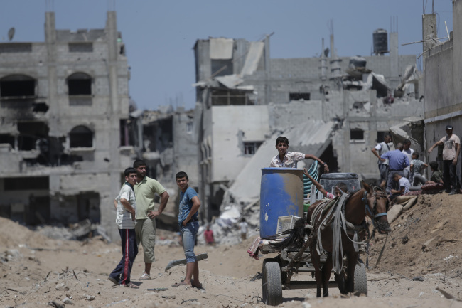 Palestinians stand amid the rubble of houses destroyed in Israeli strikes at the Shijaiyah neighborhood of Gaza City, Gaza Strip, Wednesday.   AP-Yonhap