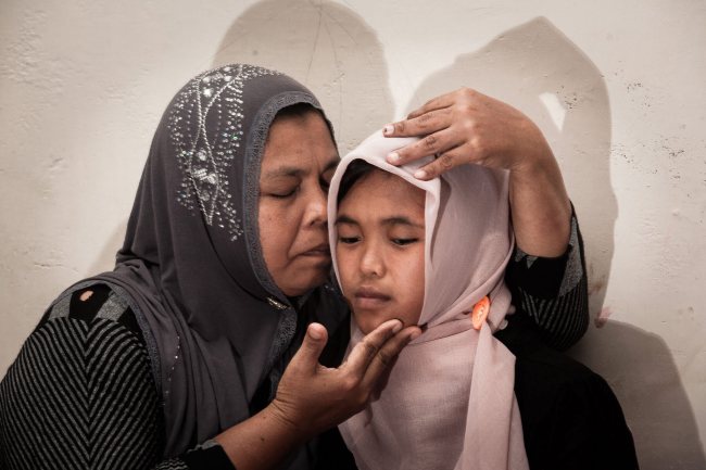 Jamaliah (left) hugs her daughter Raudhatul Jannah, a tsunami victim who was found by her family after going missing 10 years ago in Meulaboh, Aceh, Indonesia, Thursday.   Sijori Images-Yonhap
