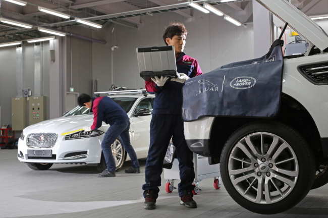 Technicians work on Jaguar Land Rover vehicles at a service center in Korea.   Jaguar Land Rover Korea