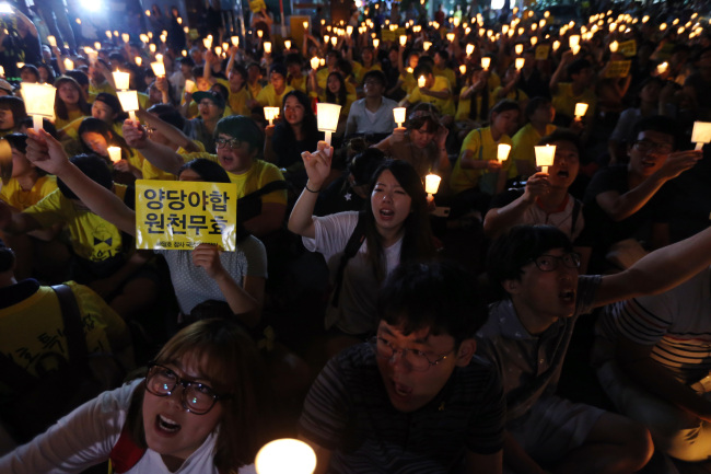 Families of those who died in the Sewol ferry accident and citizens stage a protest outside the New Politics Alliance for Democracy’s office in Seoul on Saturday.   Yonhap