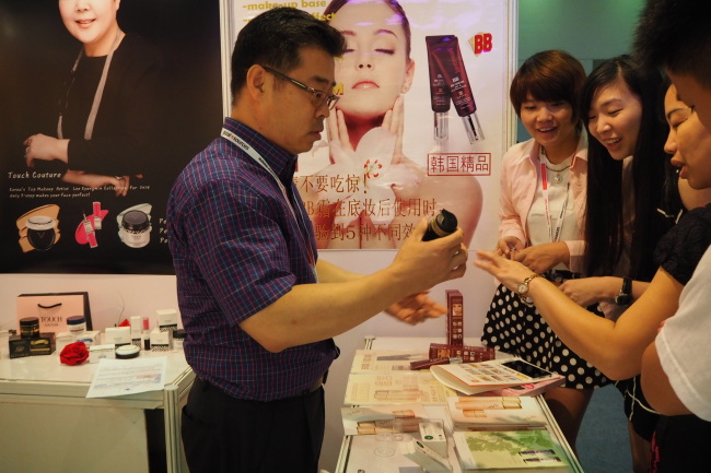 Lee Seung-jae, CEO of Aroma Newtech, presents his products to visitors at his booth at the trade show last Thursday. KITA