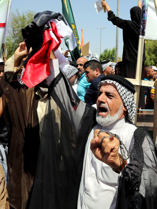 Iraqis chant pro-government slogans and wave national flags to show support for Prime Minister Nouri al-Maliki, during a demonstration in Baghdad, Iraq, Saturday.   AP-Yonhap