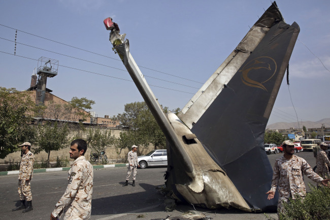 Iranian Revolutionary Guards stand alert at the site of the wreckage of a passenger plane crash near the capital Tehran on Sunday.   AP-Yonhap