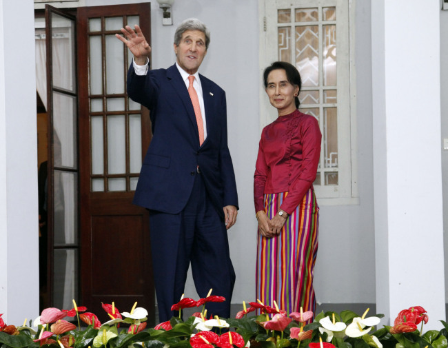 U.S. Secretary of State John Kerry (left) waves before a meeting with Myanmar opposition leader Aung San Suu Kyi at her residence in Yangon, Myanmar, Sunday.   AP-Yonhap
