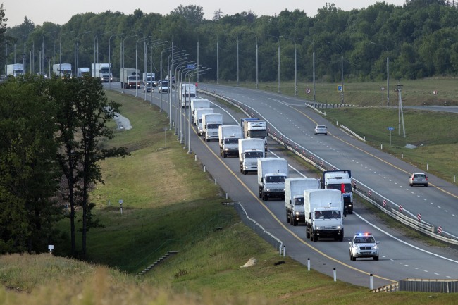 A convoy of white trucks carrying humanitarian aid passes along the main road in the Voronezh region of Russia on Tuesday.   AP-Yonhap