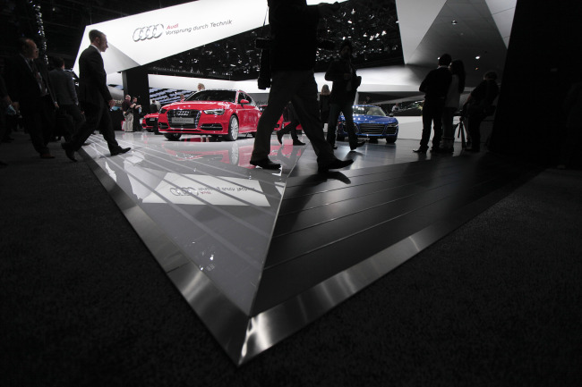 Attendees walk past the Audi stand during the 2014 North American International Auto Show in Detroit, Michigan.    (Bloomberg)