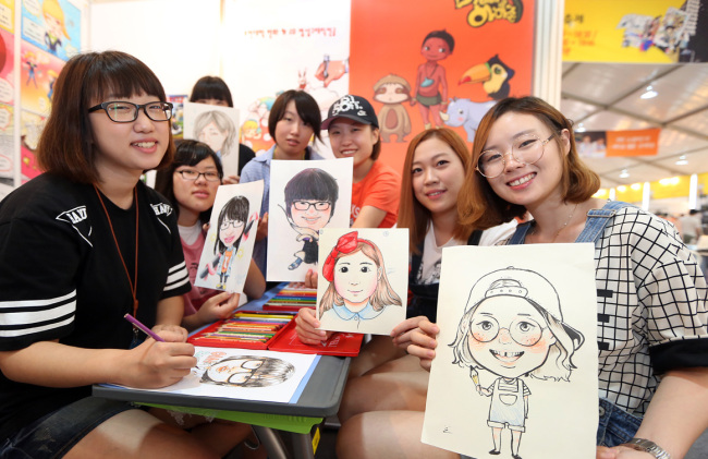 Animation majors from Korea’s Bucheon University and Japan Animation and Manga College hold up their caricatures at the 17th Bucheon International Comics Festival, which opened at the Korea Manhwa Museum on Wednesday. The festival runs until Aug. 17.   Park Hyun-koo/The Korea Herald