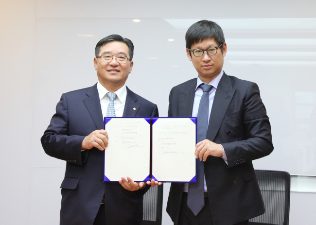 Hanwha Chemical CEO Bang Han-hong (left) poses with KPX Holdings vice chairman Yang Joon-young after signing a deal to take over KPX Fine Chemical in Seoul, Wednesday.   Hanwha Group