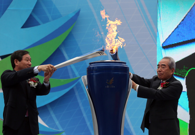 <YONHAP PHOTO-1506> 인천아시안게임 성화 합화식 (인천=연합뉴스) 신준희 기자 = 13일 오후 인천 종합문화예술회관에서 열린 2014 인천아시아경기대회 성화 합화식에서 김영수 조직위원장(오른쪽)과 유정복 인천시장이 해외 성화와 마니산 성화를 합화하는 의식을 행하고 있다. 2014.8.13 hama@yna.co.kr/2014-08-13 17:08:59/ <저작권자 ⓒ 1980-2014 ㈜연합뉴스. 무단 전재 재배포 금지.>
President of the 2014 Incheon Asian Games Organizing Committee Kim Young-soo (right) and Incheon Mayor Yoo Jeong-bok combine two flames for the Games separately lit in New Delhi, India, and at Mount Manisan, Incheon, in a ceremony on Wednesday. The combined flame will be relayed across the nation until the Games open on Sept. 19.   Yonhap