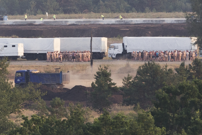 A convoy of white trucks with humanitarian aid park at the military base not far from Voronezh, Russia, Wednesday.   (AP-Yonhap)