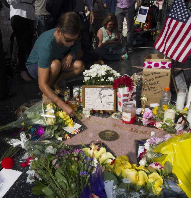 A man lays flowers at Robin Williams’ star on the Hollywood Walk of Fame in Hollywood, California, Tuesday.   Xinhua-Yonhap