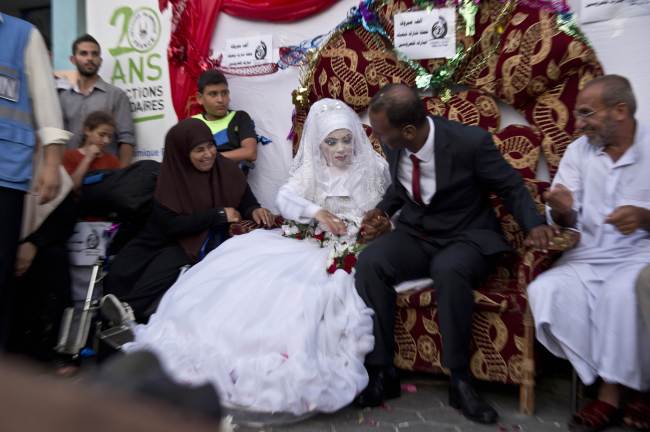 Omar Abu Namar (right) and his wife Heba Fayad attend their wedding ceremony at a U.N. school in Gaza City’s Shati refugee camp on Wednesday.   AFP-Yonhap