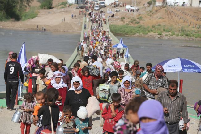 Displaced Iraqis from the Yazidi community cross the Syrian-Iraqi border along the Fishkhabur bridge over the Tigris River at the Fishkhabur crossing in northern Iraq on Wednesday.   AFP-Yonhap