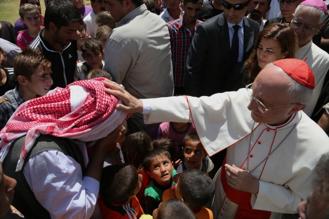 Cardinal Fernando Filoni (right), Pope Francis’ special envoy to Iraq, blesses a displaced Iraqi man from the Yazidi community at a school that was turned into a shelter for displaced Christians and Yazids in Mangesh, northern Iraq, Saturday.   AP-Yonhap