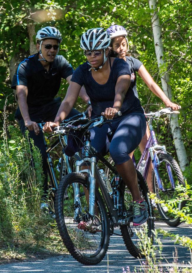 U.S. President Barack Obama (left) bikes with first lady Michelle Obama (center) and daughter Malia at Martha’s Vineyard, Massachusetts, Saturday during their annual summer vacation on the island.   AFP-Yonhap