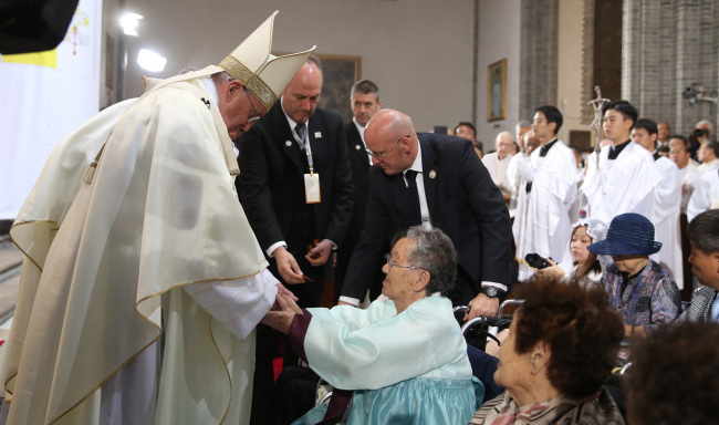 Pope Francis consoles an elderly Korean woman who was forced to serve as a sex slave for the Japanese army during World War II before the start of a Mass at Myeongdong Cathedral in Seoul on Monday. She was one of seven “comfort women” in attendance.   Joint Press