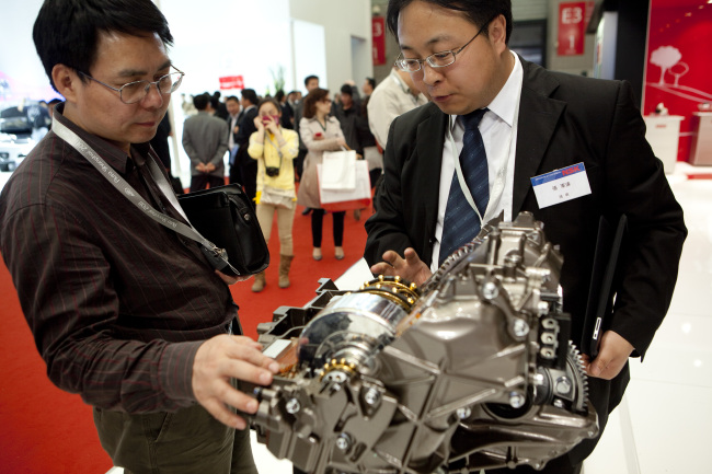 Attendees browse engine parts at the NSK Ltd. booth at the Auto Shanghai car show in China.   Bloomberg