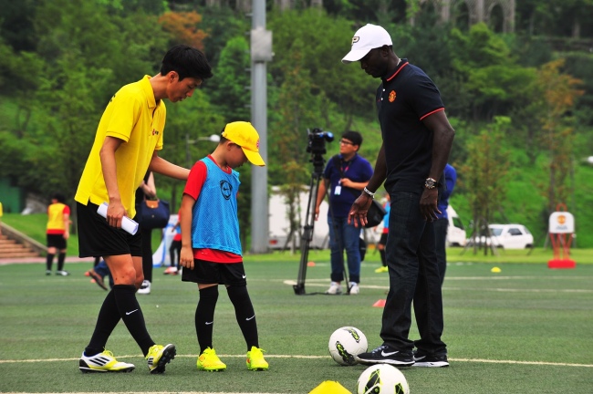 전설의 맨유 축구 선수 드와이크 요크가 드림사커스쿨에 참여한 어린이에게 축구 기술을 가르쳐 주고 있다.
전설의 맨유 축구 선수 드와이크 요크가 드림사커스쿨에 참여한 어린이에게 축구 기술을 가르쳐 주고 있다.