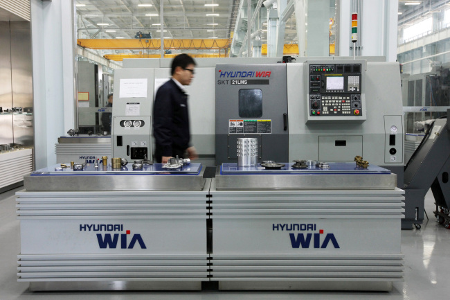 An employee walks by Hyundai Wia Corp. machine tools displayed at the company's plant in Changwon.   (Bloomberg)