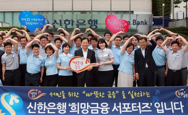 Shinhan Bank president Seo Jin-won (front row, fifth from left) poses with the members of a small-loan finance supporters group at its headquarters in Seoul in July 2013.   Shinhan Bank