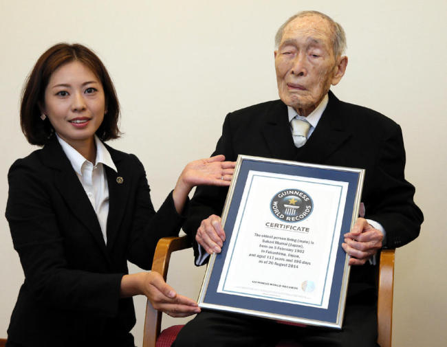 Japanese Sakari Momoi, aged 111, receives a certificate naming him as the world’s oldest man by the Guinness World Records at a hospital in Tokyo on Wednesday.   AFP