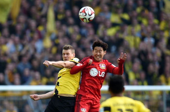 Leverkusen’s Son Heung-min (right) and Dortmund’s Lukasz Piszczek vie for the ball on Saturday.   AFP-Yonhap