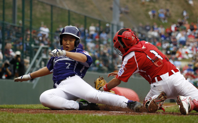 Korea’s Jeon Jin-woo slides to score a run in the second inning against Japan on Saturday.   AP-Yonhap