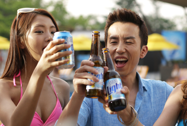 Singer Yoo Hee-yeol (right), advertising model for OB’s low-calorie beer Cass Light.   OB