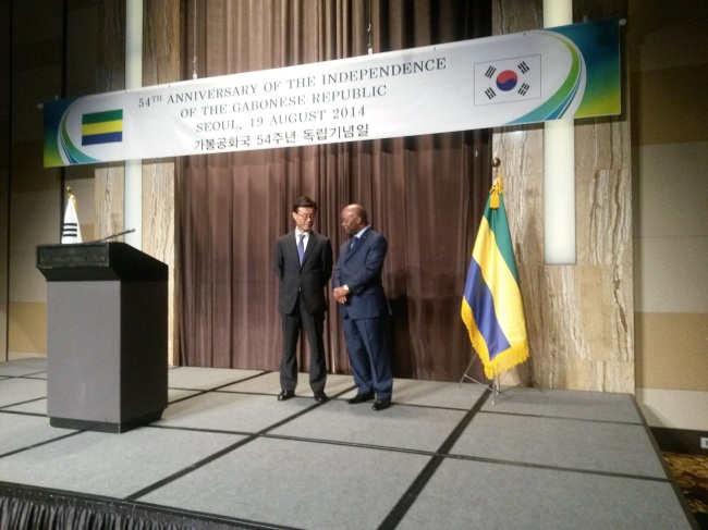 Gabonese Ambassador to South Korea Carlos Victor Boungou (right) and Choi Sung-joo, ambassador for international security affairs, chat on stage during a reception celebrating the Central African country’s 54th National Day in Seoul on Tuesday. (Philip Iglauer/The Korea Herald)