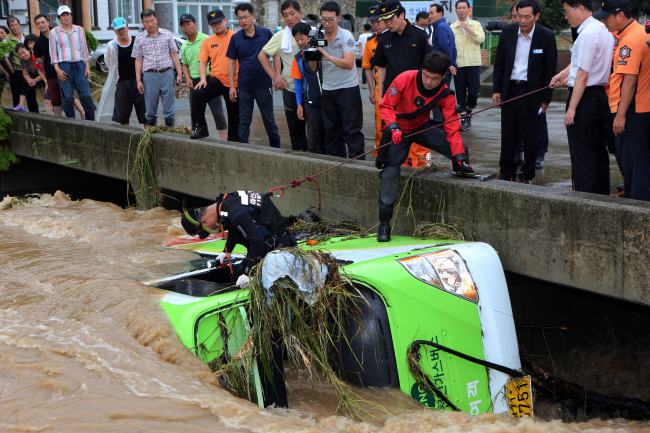 TORRENTIAL RAIN -- A destroyed bus drifts to a stop against a bridge in Changwon, South Gyeongsang Province, Monday. Yonhap